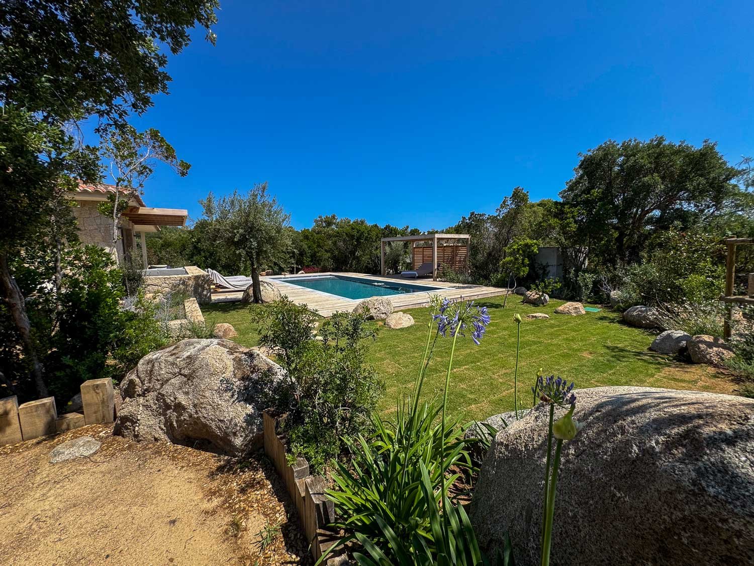 Jardin de la villa neuve de 3 chambres avec piscine chauffée, située dans le Domaine privé Punta Arasu à Porto Vecchio