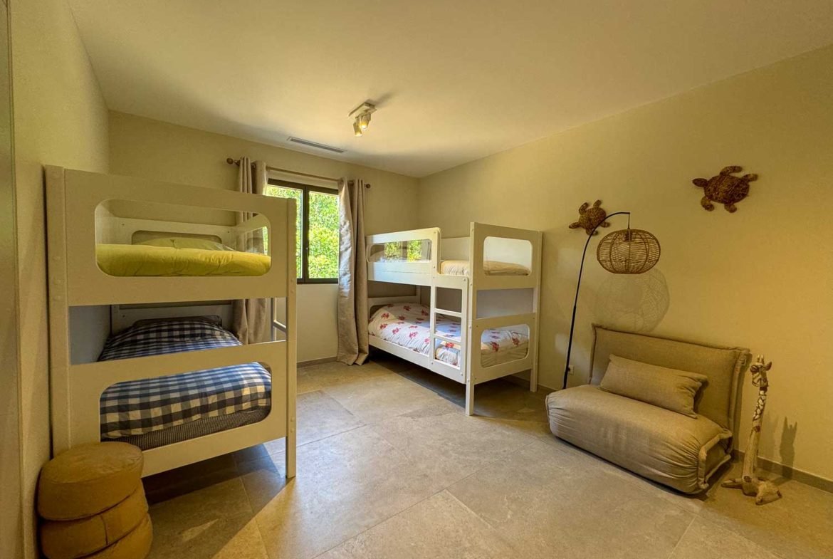 Chambre enfants et vue sur le jardin dans la villa de luxe du Domaine privé Punta Arasu