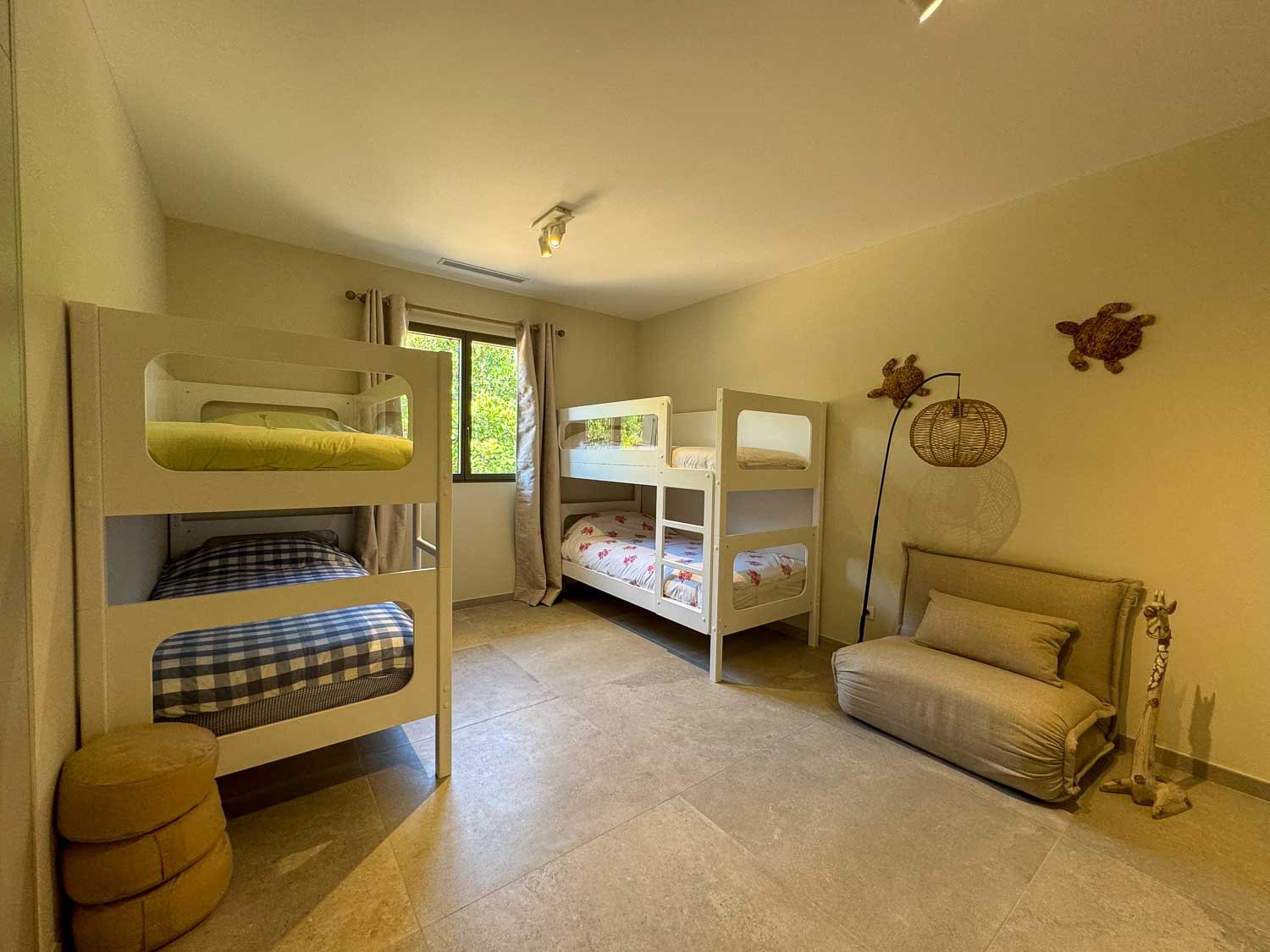 Chambre enfants et vue sur le jardin dans la villa de luxe du Domaine privé Punta Arasu